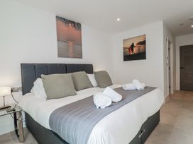 A bedroom with a bed and wall art at 13 Cliff Edge in Newquay
