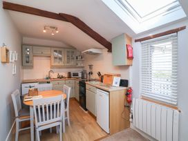 A kitchen with dining table and appliances at Ash Cottage Combe Martin