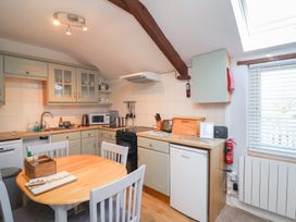 A kitchen with appliances and dining table at Ash Cottage in Combe Martin