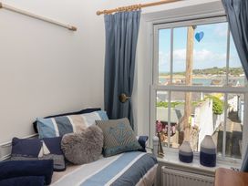 A bedroom with a window view at Honeymoon Cottage in Appledore
