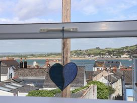 A view from a window showing houses and ocean at Honeymoon Cottage in Appledore