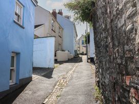 An alley with blue houses and a stone wall at Honeymoon Cottage in Appledore