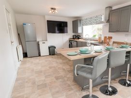 A kitchen with a refrigerator and a dining table at Whinney Moor 