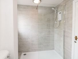 A shower area with tile walls and shower control unit at Whinney Moor in 