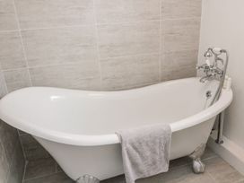 A bathtub with a towel hanging on it at Whinney Moor