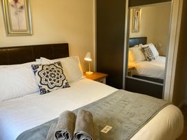 A bedroom with a bed, bedside lamp, and mirror at Bugle in Saltburn-By-The-Sea