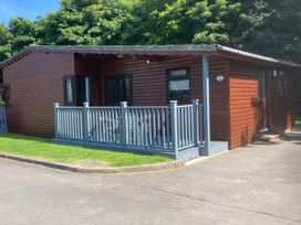 A log cabin with a deck and table with chairs at Lavender Lodge in Saltburn-By-The-Sea