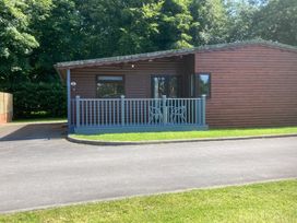 A log cabin with a porch and chairs at Lavender Lodge in Saltburn-By-The-Sea