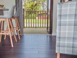 A kitchen with bar stools and a door leading to a deck at Lavender Lodge in Saltburn-By-The-Sea