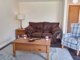 A living room with a brown sofa and wooden coffee table at Lavender Lodge in Saltburn-By-The-Sea