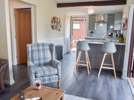 A living room with a chair and kitchen counter at Lavender Lodge in Saltburn-By-The-Sea
