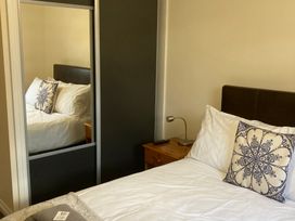 A bedroom with a bed and mirror at Lavender Lodge in Saltburn-By-The-Sea