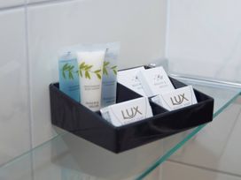 A bathroom display with toiletries including shower gel, shampoo, body lotion, and soap at Lavender Lodge in Saltburn-By-The-Sea
