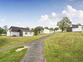 Outdoor area with bungalows and a pathway at Harcombe House Pet Free Bungalow in Chudleigh