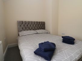 A bedroom with a double bed with two pillows and folded towels on the bed at Cae Iocyn in Chirk