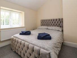 A bedroom with a double bed and folded towels on the bed at Cae Iocyn in Chirk