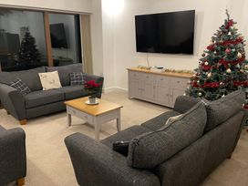 A living room with a sofa and Christmas tree at Pol View in Helston