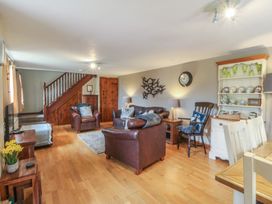 A living room with a sofa, chairs, and a dining table at Beudy Penarddwnion in Rhydymain near Dolgellau