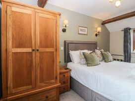 A bedroom with a bed and wardrobe at Beudy Penarddwnion near Rhydymain