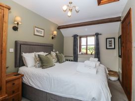 A bedroom with a bed and wardrobe at Beudy Penarddwnion near Rhydymain
