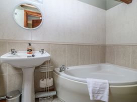 A bathroom with a bath tub and sink at Beudy Penarddwnion near Rhydymain