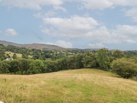 A landscape view of a field and mountains at Beudy Penarddwnion in Rhydymain near Dolgellau