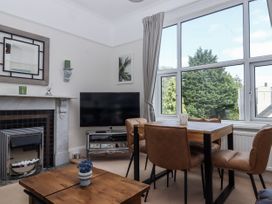 A dining room with a television and a fireplace at Kinbrae Apartment in Torquay