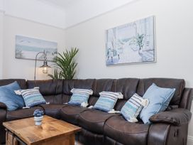 A living room with a brown sofa and wall art at Kinbrae Apartment in Torquay