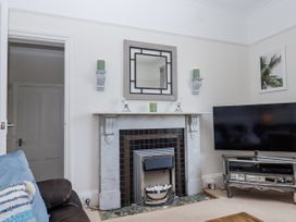 A living room featuring a fireplace and television at Kinbrae Apartment in Torquay
