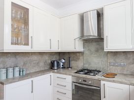 A kitchen with cabinets and appliances at Kinbrae Apartment in Torquay