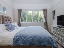 A bedroom with a bed and a television at Kinbrae Apartment in Torquay