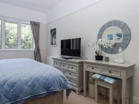 A bedroom with a bed and television in Kinbrae Apartment Torquay