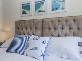 A bedroom featuring a bed with decorative pillows at Kinbrae Apartment in Torquay