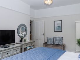 A bedroom with a television and a sofa at Kinbrae Apartment in Torquay
