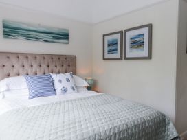 A bedroom with a bed and decorative items at Kinbrae Apartment in Torquay