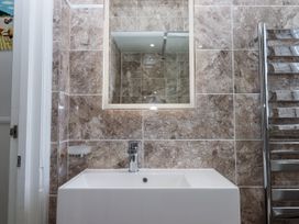 A bathroom with a sink and mirror at Kinbrae Apartment in Torquay