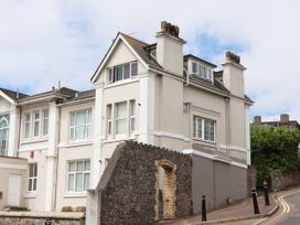 A building with windows and a brick wall near a road at Kinbrae Apartment in Torquay