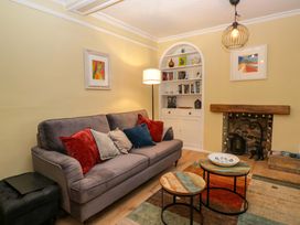 A living room with a sofa and bookshelf at 1 Tower House in Cartmel
