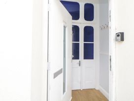 An entrance hallway with open white doors and wooden floor at 11 Magdalene Road in Torquay
