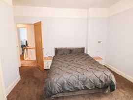 A bedroom with a bed with gray bedding and two bedside tables with lamps at 11 Magdalene Road in Torquay