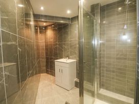 A bathroom with a white vanity sink and a glass shower area at 11 Magdalene Road in Torquay