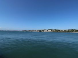 A coastal view with buildings and trees along the shoreline at 11 Magdalene Road in Torquay