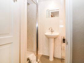 A small bathroom with a pedestal sink a mirror a shower cubicle and a soap dispenser at Midhurst in Brixham