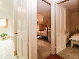 View of two bedrooms with beds and open doors next to a bathroom with a window and a plant at Midhurst in Brixham