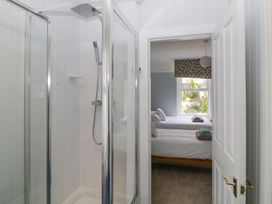 A shower cubicle in a bathroom with a view into a bedroom with two single beds and a window at Midhurst in Brixham