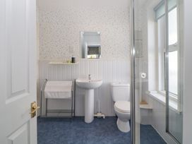 A bathroom with a pedestal sink toilet towel rack and shower at Midhurst in Brixham