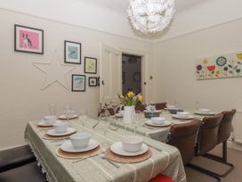 A dining room with a set table with bowls glasses and a vase of flowers at Midhurst in Brixham