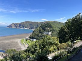 A coastline view with mountains and buildings at Oak Cottage in North Molton
