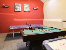 A game room with a ping pong table billiards table and air hockey table with comic posters on the wall at Beechcroft Cottage in North Molton
