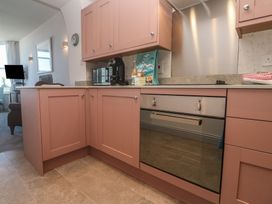 A kitchen with pink cabinets and appliances at Heron in St Ives